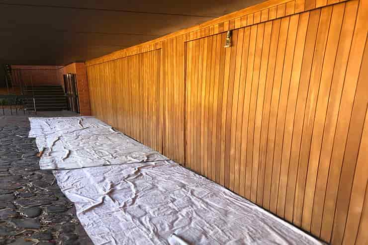 A wooden wall covered with a tarp, indicating preparation for deck varnishing and clear coating in Adelaide.