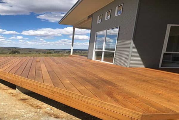 A wooden deck in front of a house, showcasing a blend of aluminum and metal painting elements.