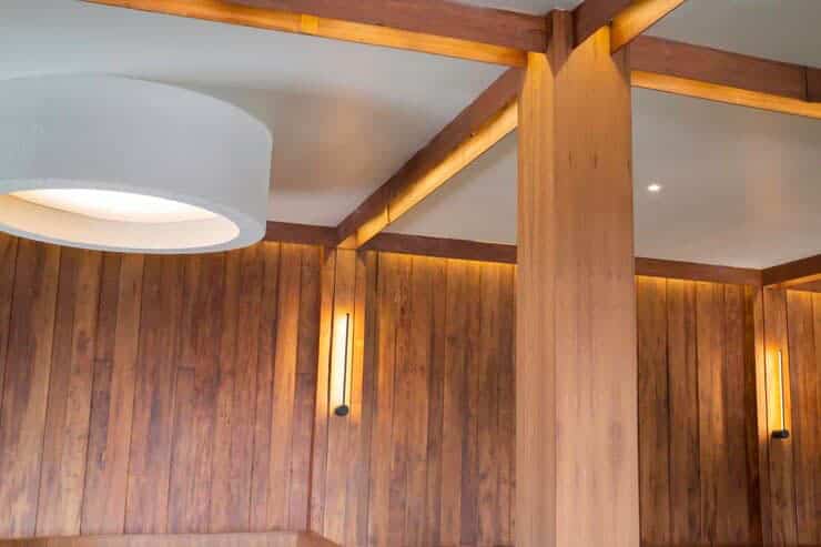 A wooden wall with a light fixture and a wooden ceiling, showcasing an aluminum and metal painting.
