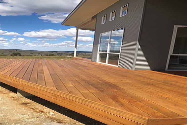 A well-maintained wooden deck adjacent to a house, emphasizing the quality of deck varnishing and clear coating in Adelaide.