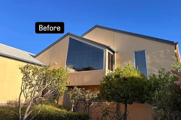 Exterior view of a house with a worn roof, illustrating its condition before any repairs were made.