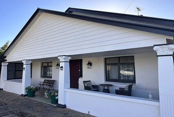 A house featuring a welcoming porch and a spacious patio for outdoor relaxation.