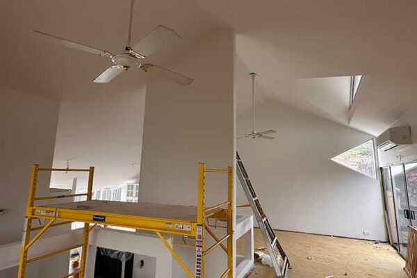 Interior view of a room containing a ladder and a ceiling fan, highlighting elements of utility and comfort.