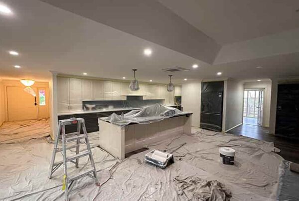 An interior kitchen remodel in progress, showcasing a ladder and tools scattered around the space.