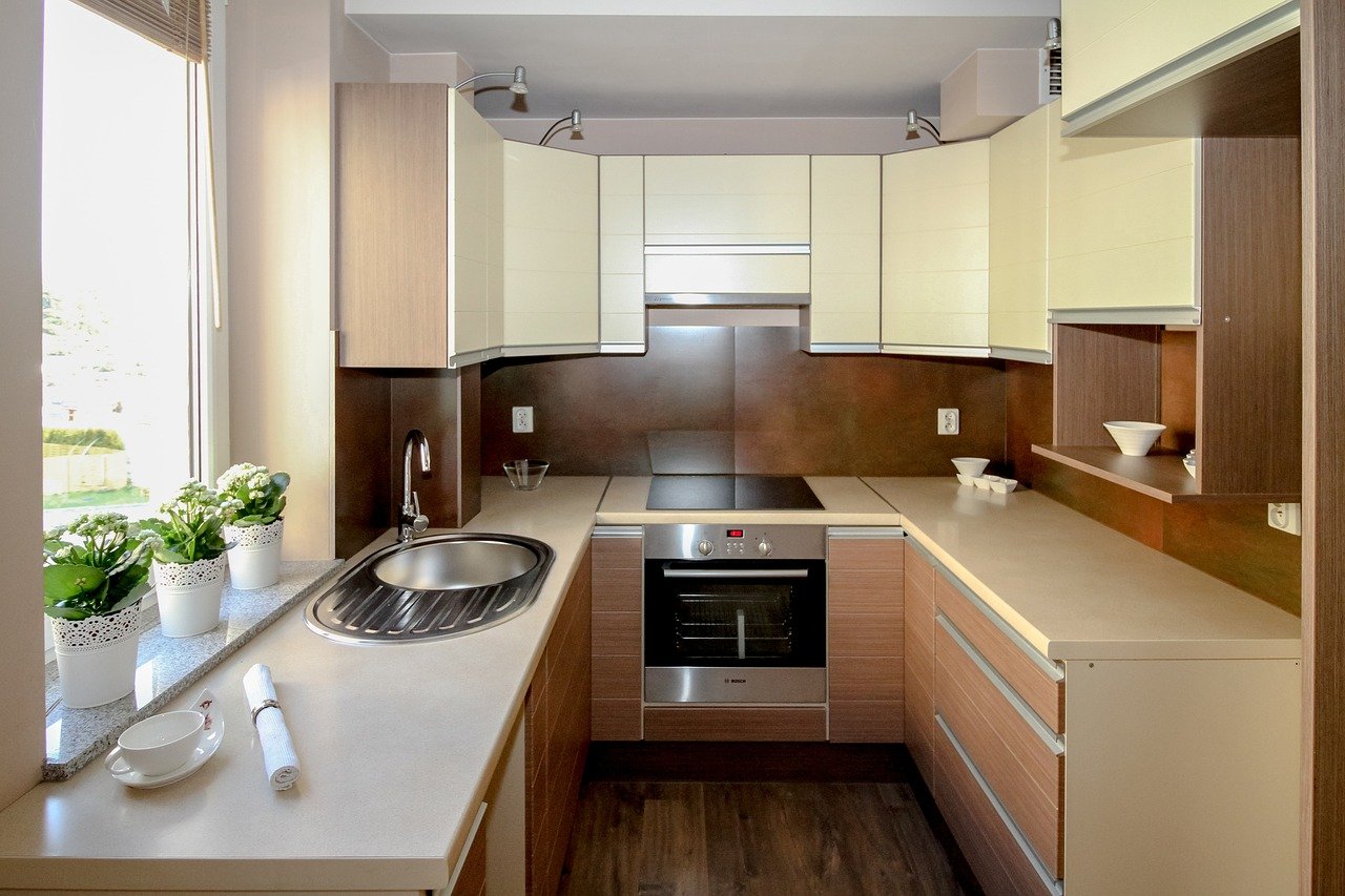 A compact kitchen featuring a sink, oven, and microwave, designed for efficient cooking and meal preparation.