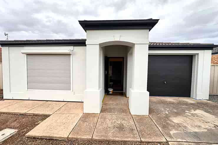 A digital rendering of a house with an attached garage and a paved driveway.