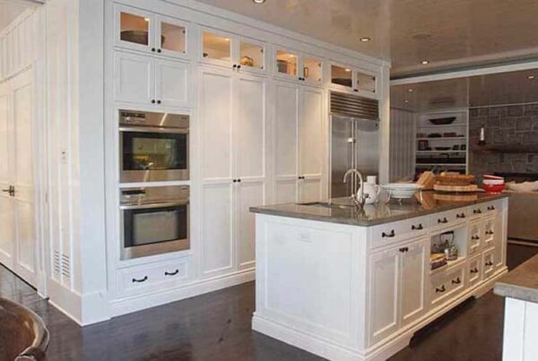 Bright kitchen with white cabinetry and a central island, highlighting a fresh and inviting residential painting design.